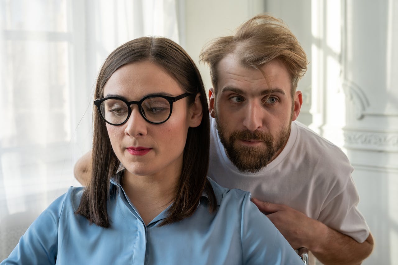 who-we-are A man and woman engaged in a thoughtful discussion indoors, showcasing emotions.