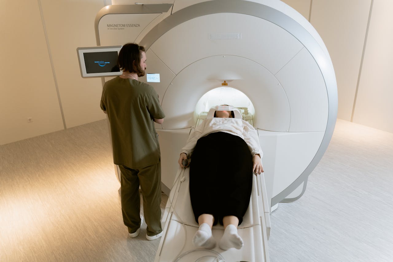 services-01 A patient undergoing an MRI scan with a healthcare professional present in a modern medical facility.